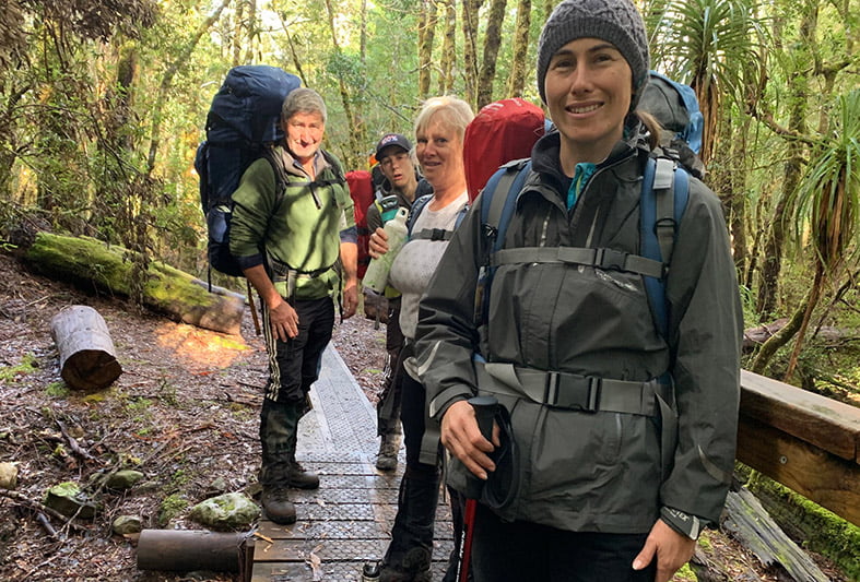 Photo of a woman with hikers in the background on a trail